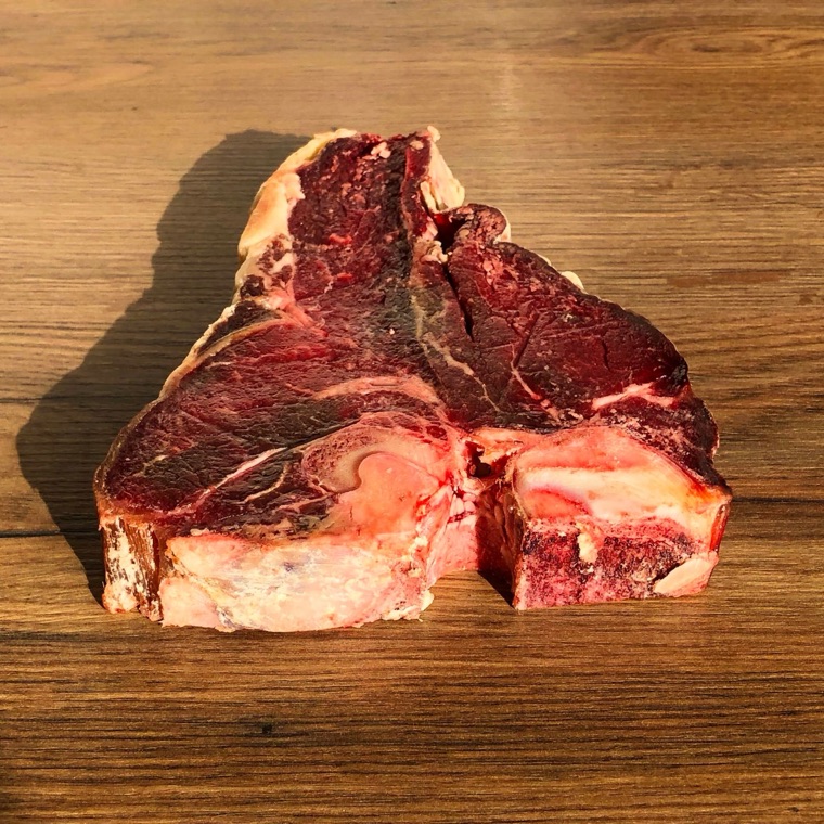 A raw T-bone steak on a wooden table
